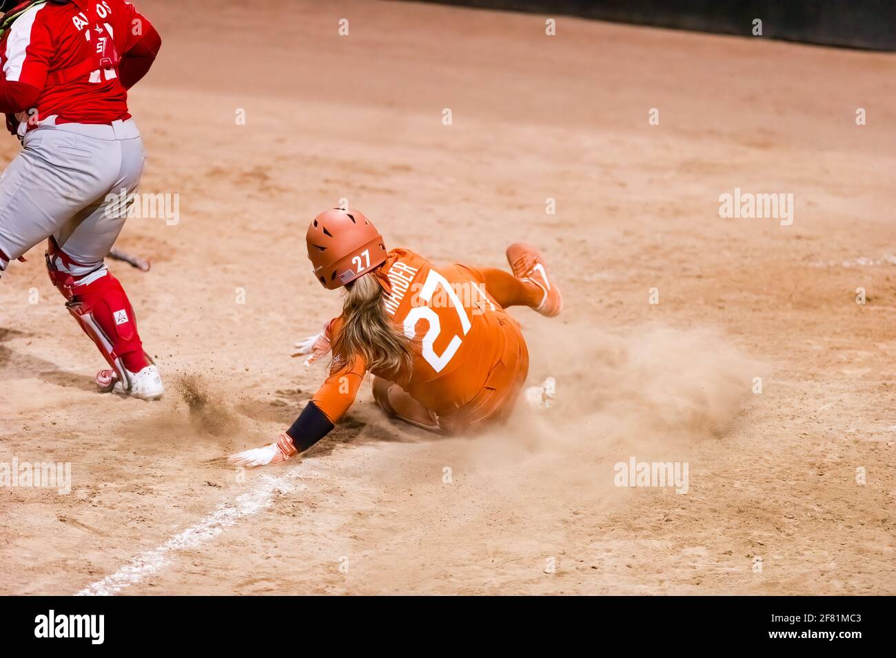 A Texas Longhorn Player is Sliding Into Home Plate Scoring A Run Stock Photo