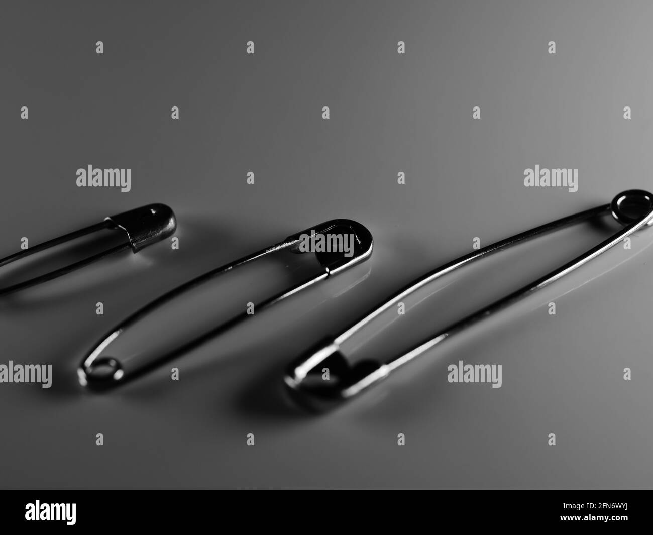 Safety pins on table Black and White Stock Photos & Images - Alamy