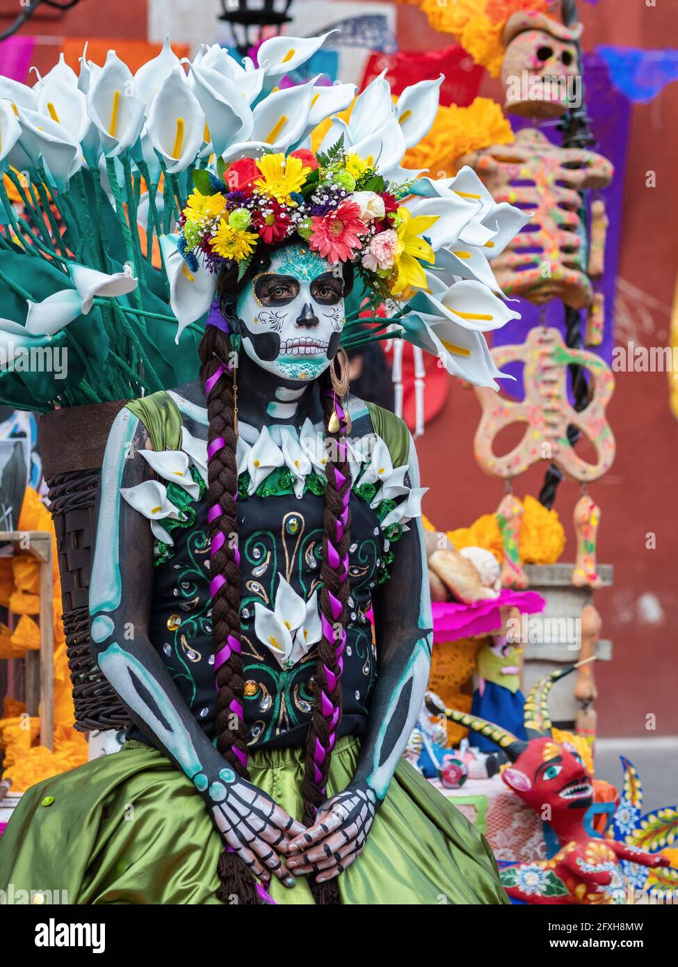 Portrait of a woman wearing beautiful Day of the Dead costumes and skull makeup on the streets of Guanajuato City, Mexico. Stock Photo