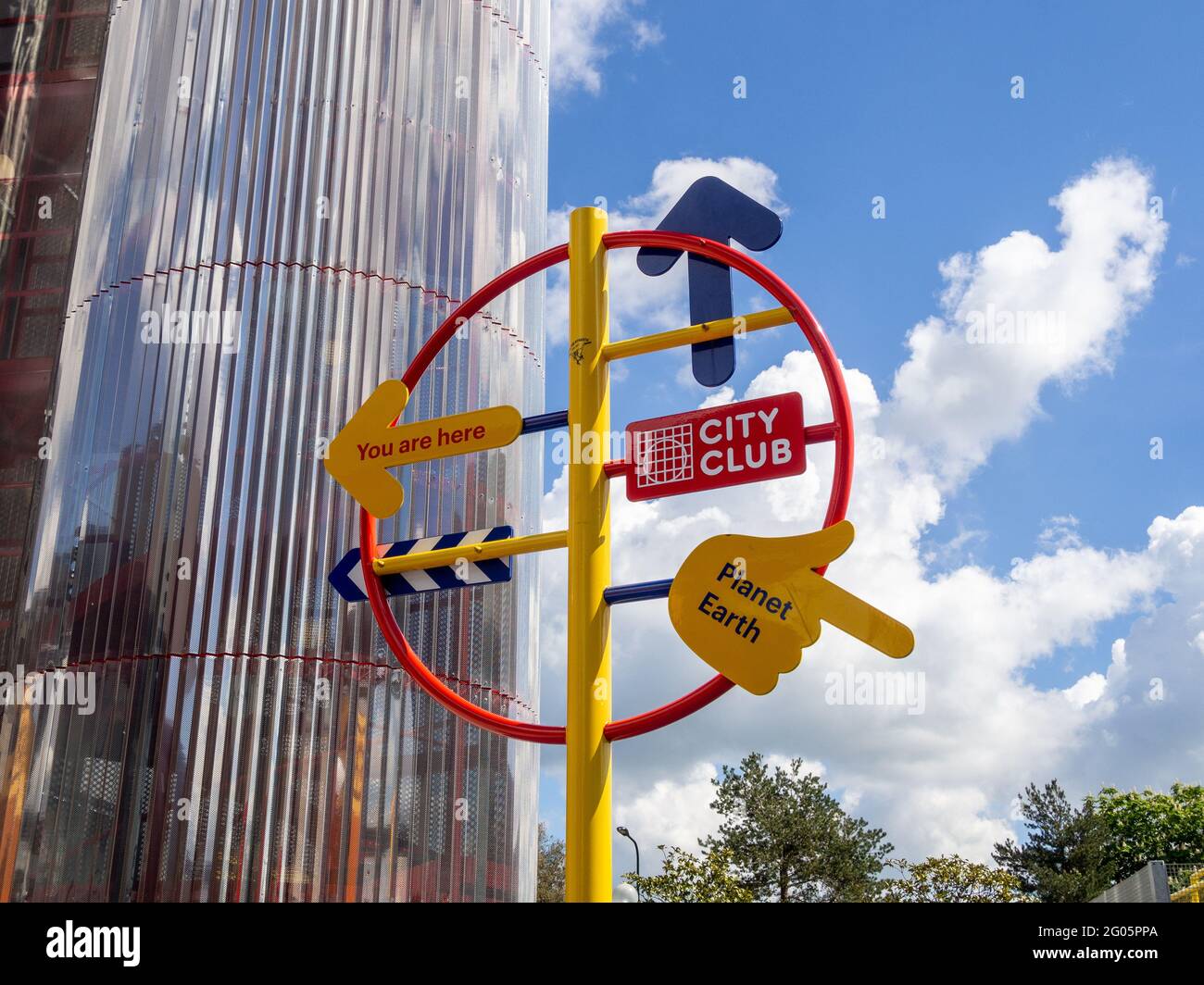 Colourful circular metal signpost giving directions to various attractions, Milton Keynes, UK Stock Photo