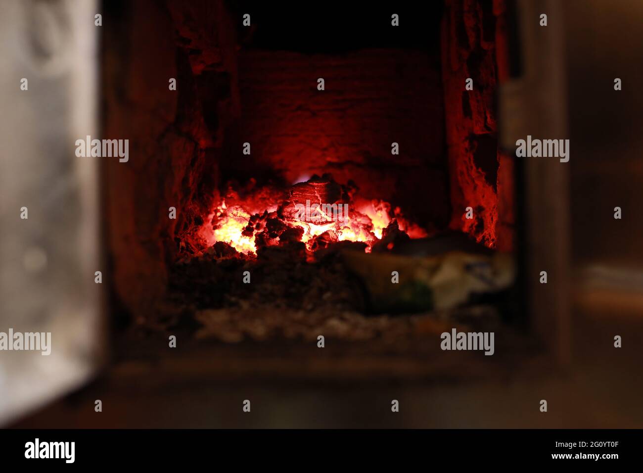 heated stove in the house with red coals and fire Stock Photo