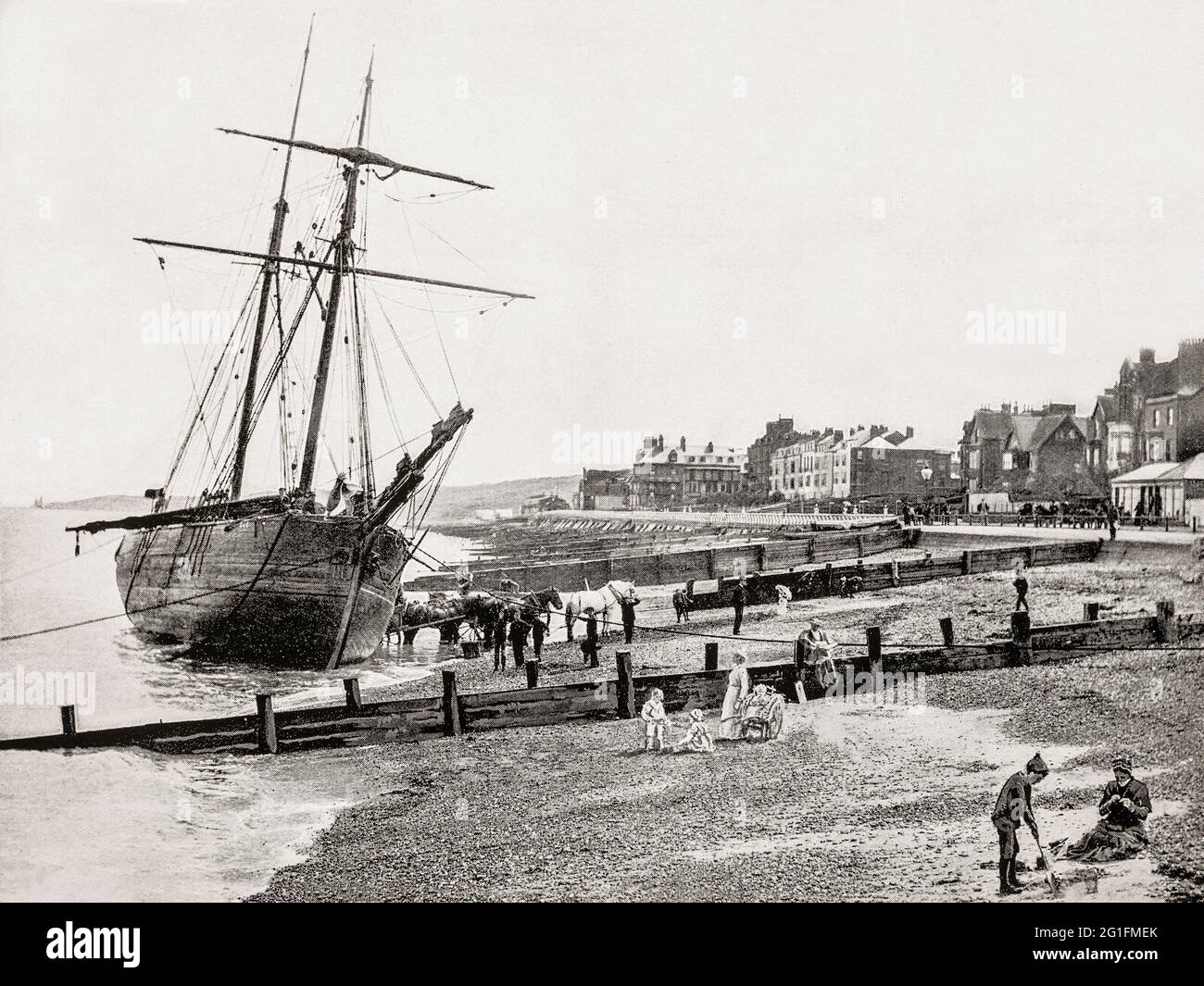 A late 19th century view of a sailing boat beached on the sands of Herne Bay, a seaside town in Kent, England. The town began as a small shipping community, receiving goods and passengers from London en route to Canterbury and Dover. It rose to prominence as a seaside resort during the early 19th century after the building of a pleasure pier and promenade when steamboats began running between Herne Bay and London. Stock Photo