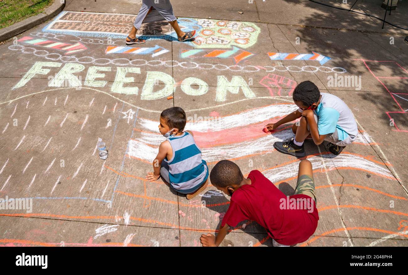 Philadelphia, Pennsylvania, USA. 19th June, 2021. Children color a flag with chalk Saturday during a Juneteenth celebration in Malcolm X Park in Philadelphia, Pennsylvania. Juneteenth was celebrated as a federal holiday for the first time after President Biden signed the bill into law Thursday. Credit: Jim Z. Rider/ZUMA Wire/Alamy Live News Stock Photo