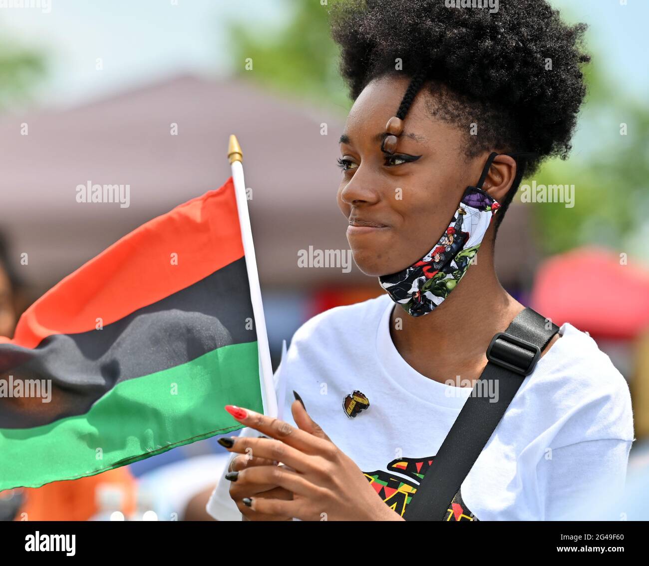 Scranton, United States. 19th June, 2021. A young black woman holds a Black Liberation Flag during a Juneteenth celebration.President Joe Biden signed into law legislation that would establish June 19 as Juneteenth National Independence Day. Juneteenth is the celebration of the emancipation of blacks. Scranton held a block party for families to celebrate the holiday. Credit: SOPA Images Limited/Alamy Live News Stock Photo