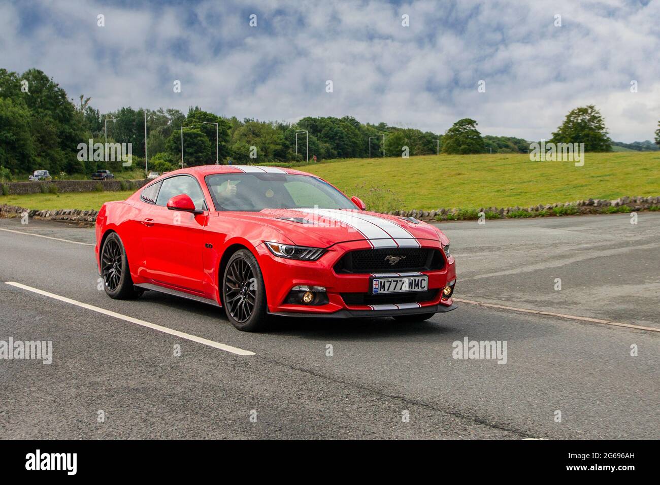 2016 red Ford Mustang 6 speed manual, 4951 cc muscle car en-route to Leighton Hall classic car July car show, Carnforth, Lancashire UK Stock Photo