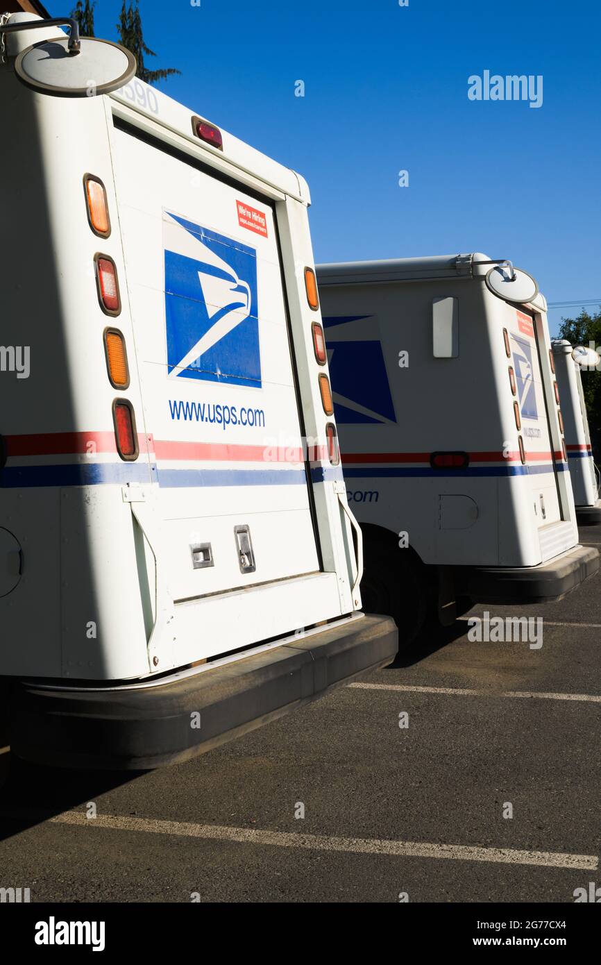 Carnation, WA, USA - July 11, 2021; A row of small USPS postal service vans in the sun under a blue sky Stock Photo