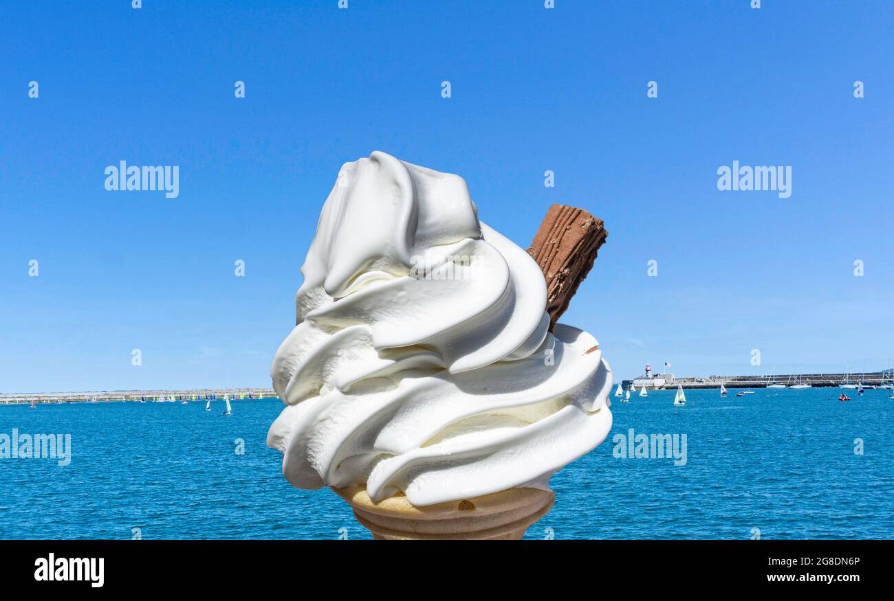 A 99 ice cream set against a blue sky and clear blue sea. Stock Photo