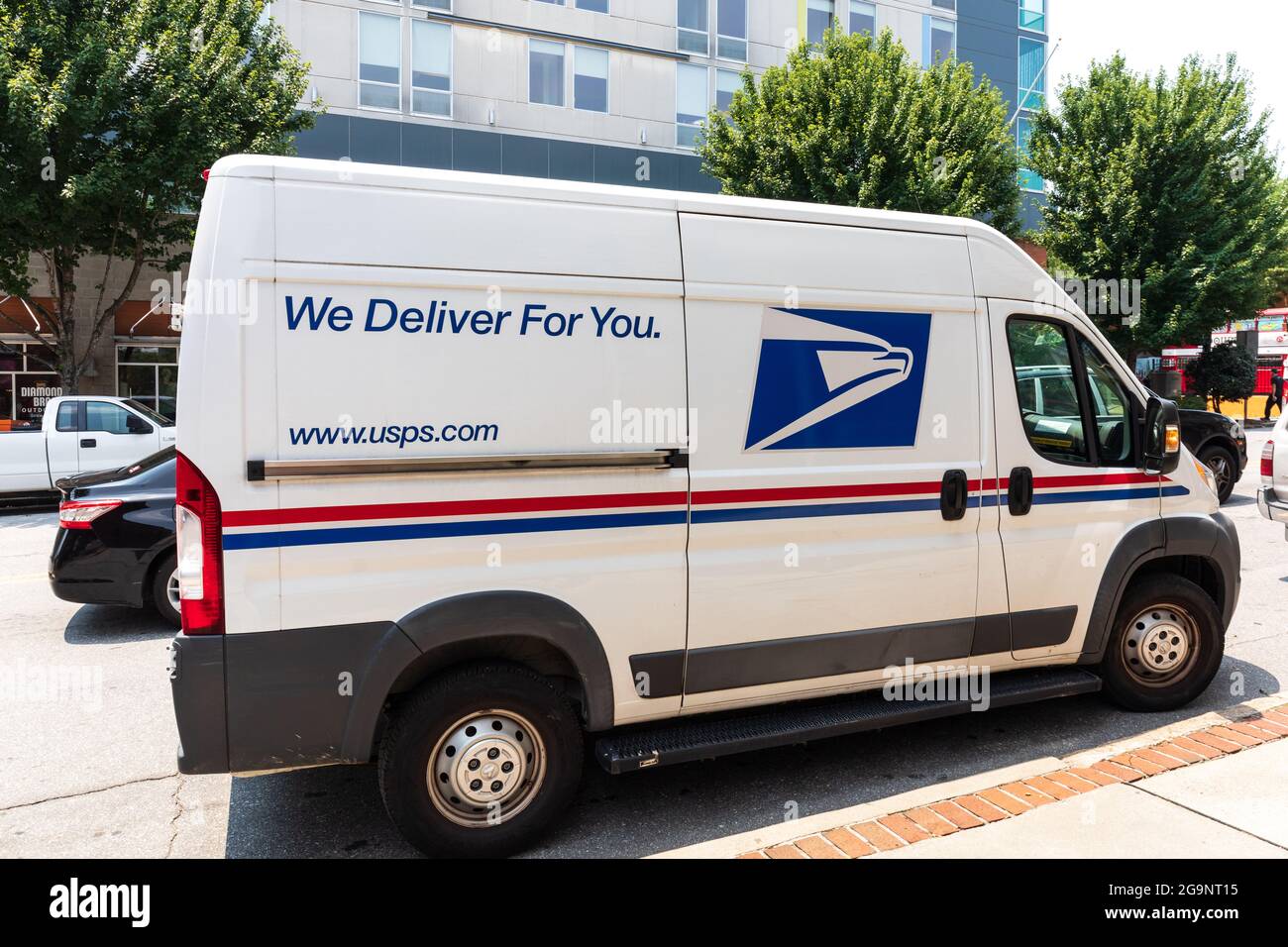 ASHEVILLE, NC, USA-22 JULY 2021: Image of a white Dodge Ram Postal delivery van, at curbside.  Lettering-'We Deliver For You' and ' www.usps.com' Stock Photo