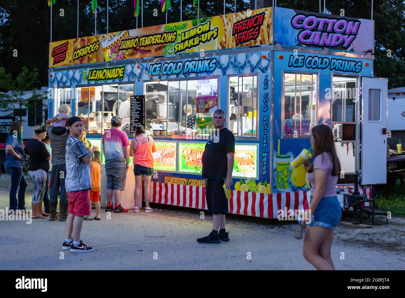 People gather in front of a junk food vendor at the 2021 Noble County Fair in Kendallville, Indiana, USA. Stock Photo