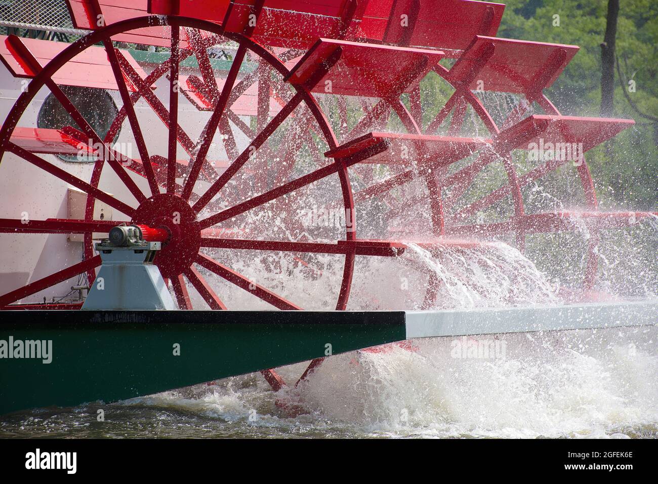 close up of red paddlewheel boat on a river with water spray Stock Photo