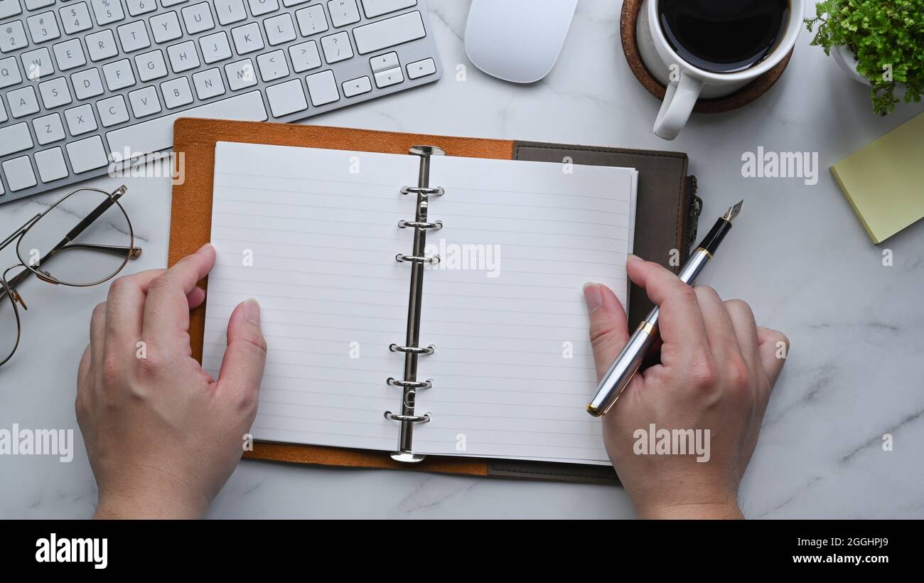 Top view man holding pen and empty notebook Stock Photo - Alamy