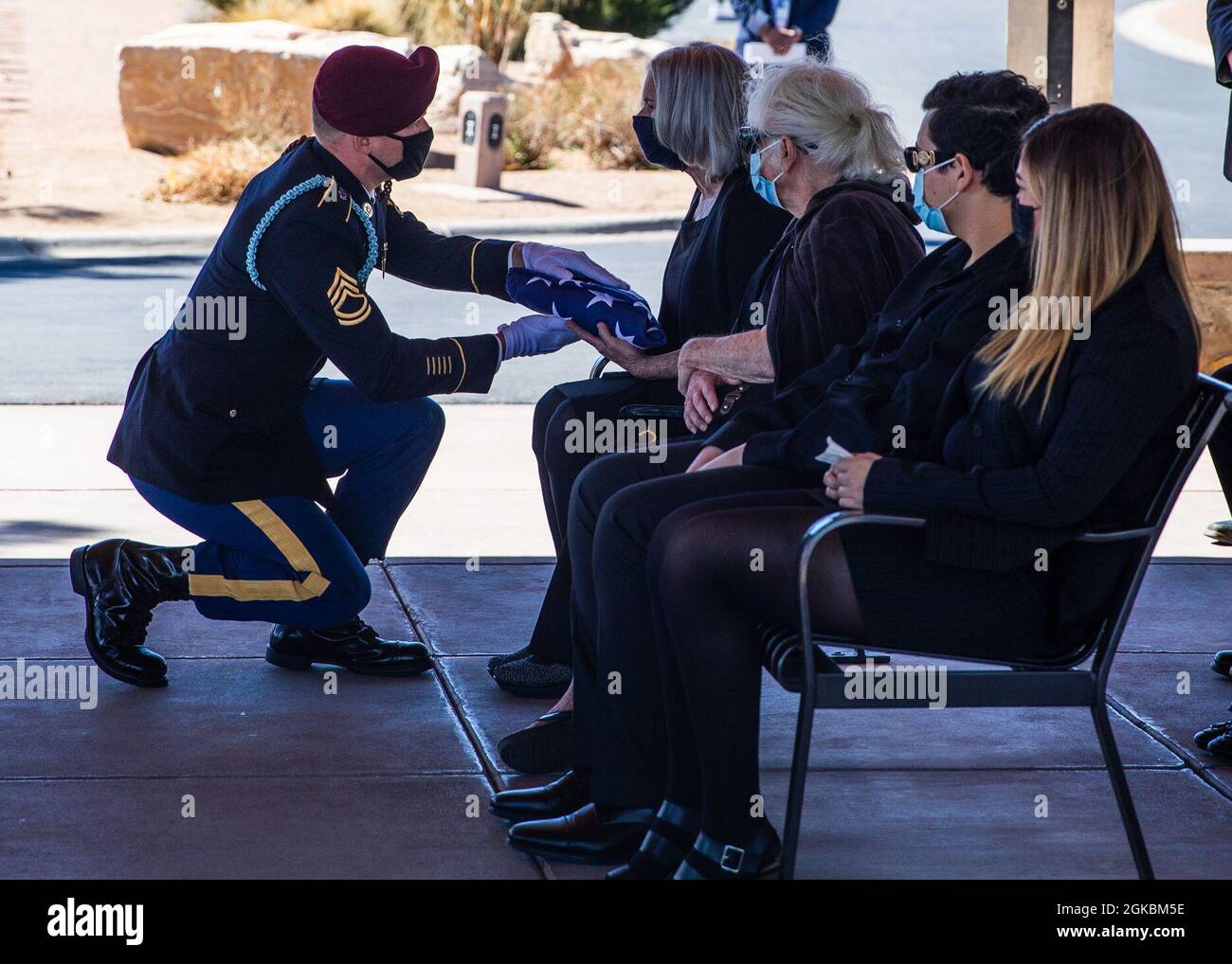 Sgt. 1st Class Micheal Stroud, a platoon sergeant assigned to D Company, 2nd Battalion, 325th Airborne Infantry Regiment, 2nd Brigade Combat Team, 82nd Airborne Division, presents the U.S. Flag to Marlene Ritts, the daughter of recently deceased Pfc. Harvey Brown, during a funeral service at Fort Bliss National Cemetery on Fort Bliss, Texas, March 5, 2021. Pfc. Brown served in World War II with 2nd Battalion, 505th Parachute Infantry Regiment, 82nd Abn. Div. and fought in Italy, France, The Netherlands and Belgium. Stock Photo