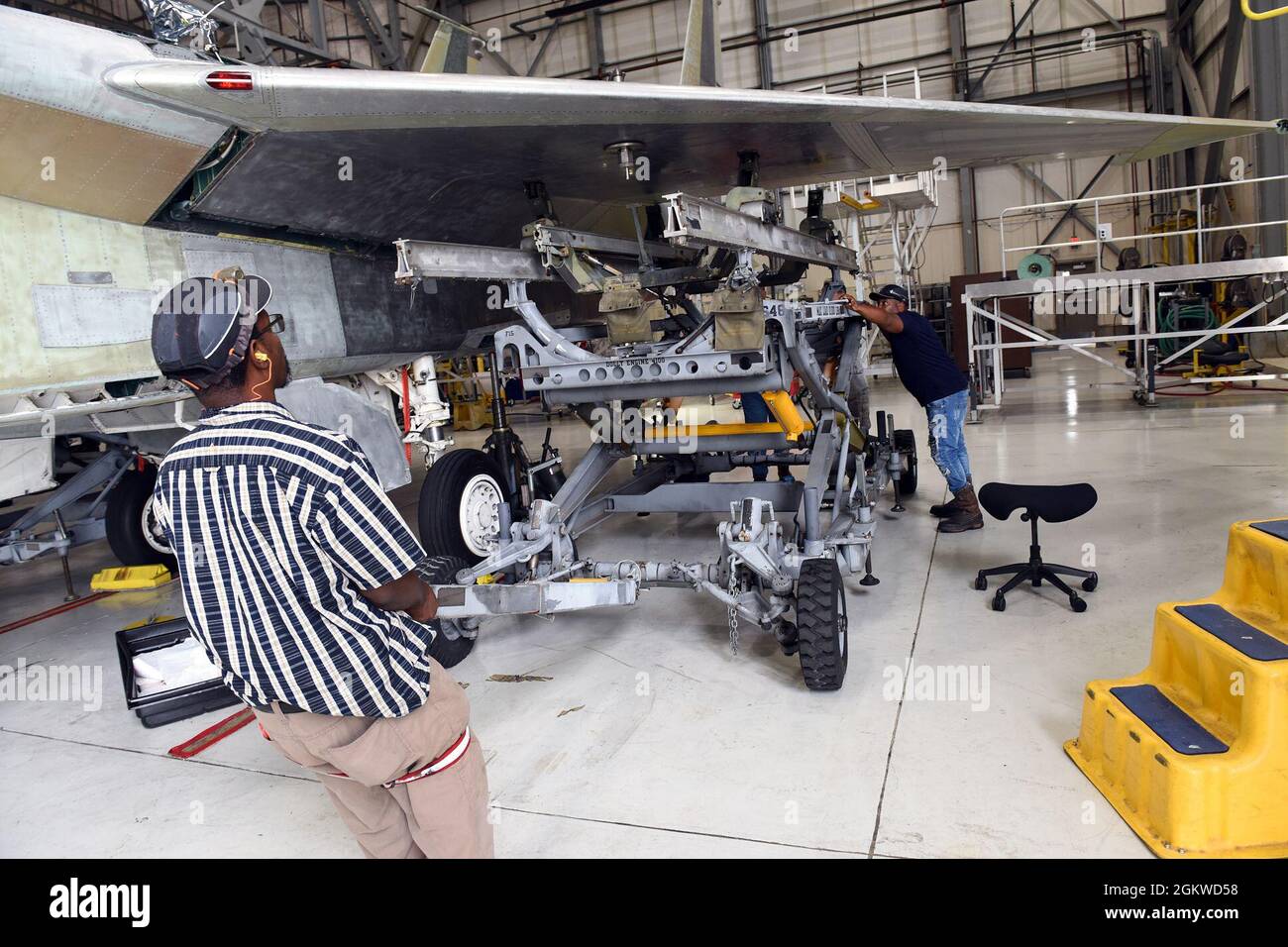 Members of the 561st Aircraft Maintenance Squadron with the Warner Robins Air Logistics Complex position a support stand beneath the left wing of an F-15 Eagle aircraft at Robins Air Force Base, Georgia, July 8, 2021. The 561st AMXS accomplishes inspection, modification, maintenance and repair on F-15 aircraft. Stock Photo