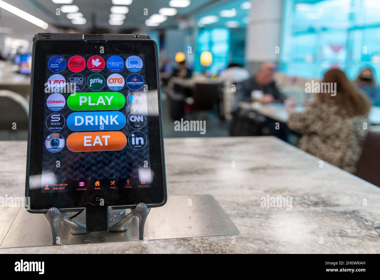 Restaurant tablet with menu, ordering and paying apps, and other apps seen on a restaurant table in Pearson International Airport in Toronto city, Can Stock Photo