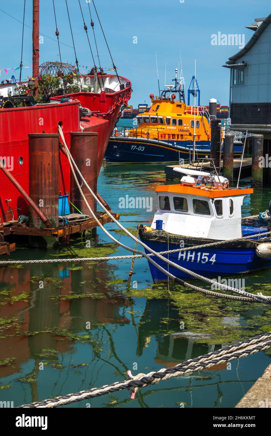 Bow of ex-trinity house lightship LV18, a RNLI Lifeboat and smaller boat Harwich Essex England Stock Photo