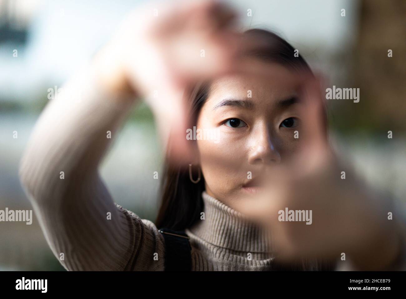 Close up of a young Asian teenage girl framing with her hands Stock Photo