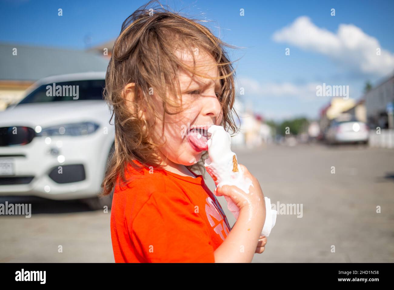 Caucasian girl with messy face and hands eating ice cream cone Stock Photo