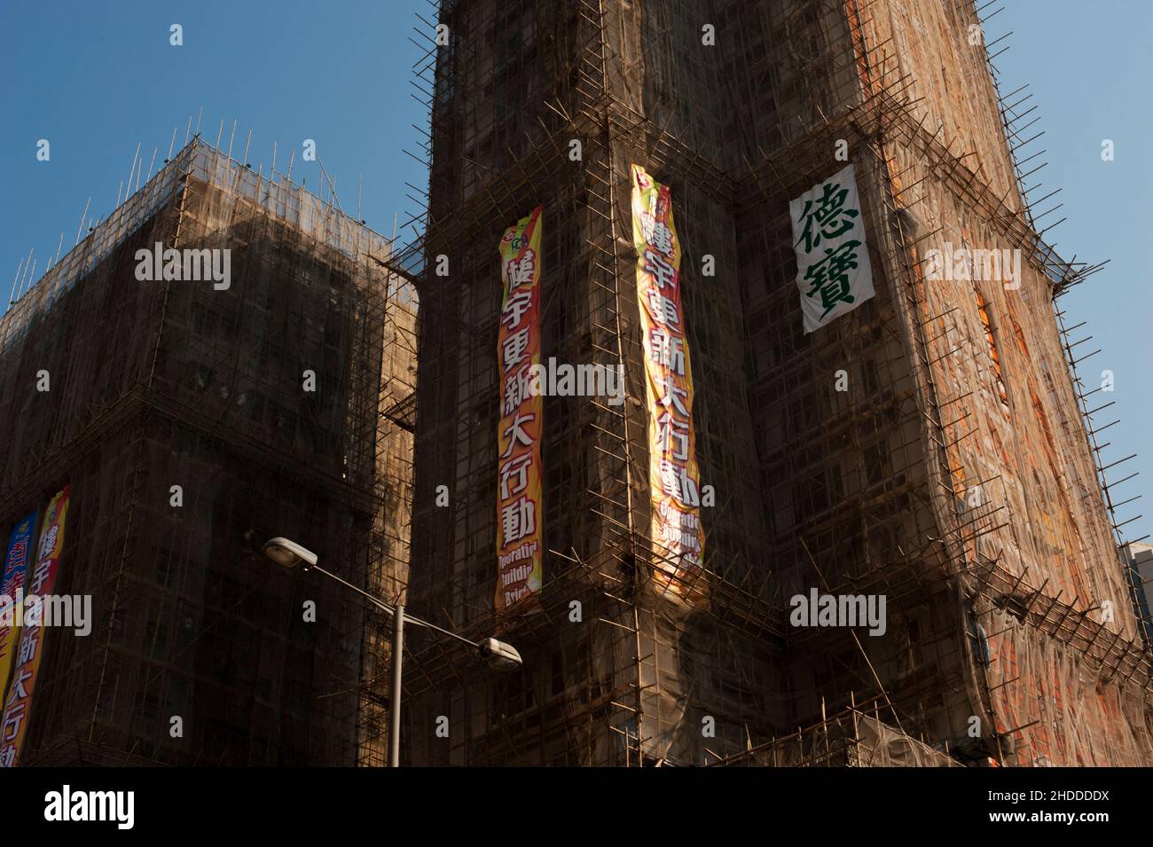 Scaffolding cloaks a multi-story tower building in Hong Kong. Stock Photo