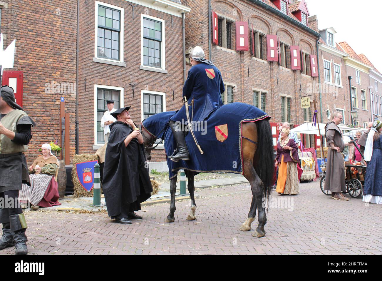 a knight on horseback walks in the streets during medieval times festivities in summer Stock Photo