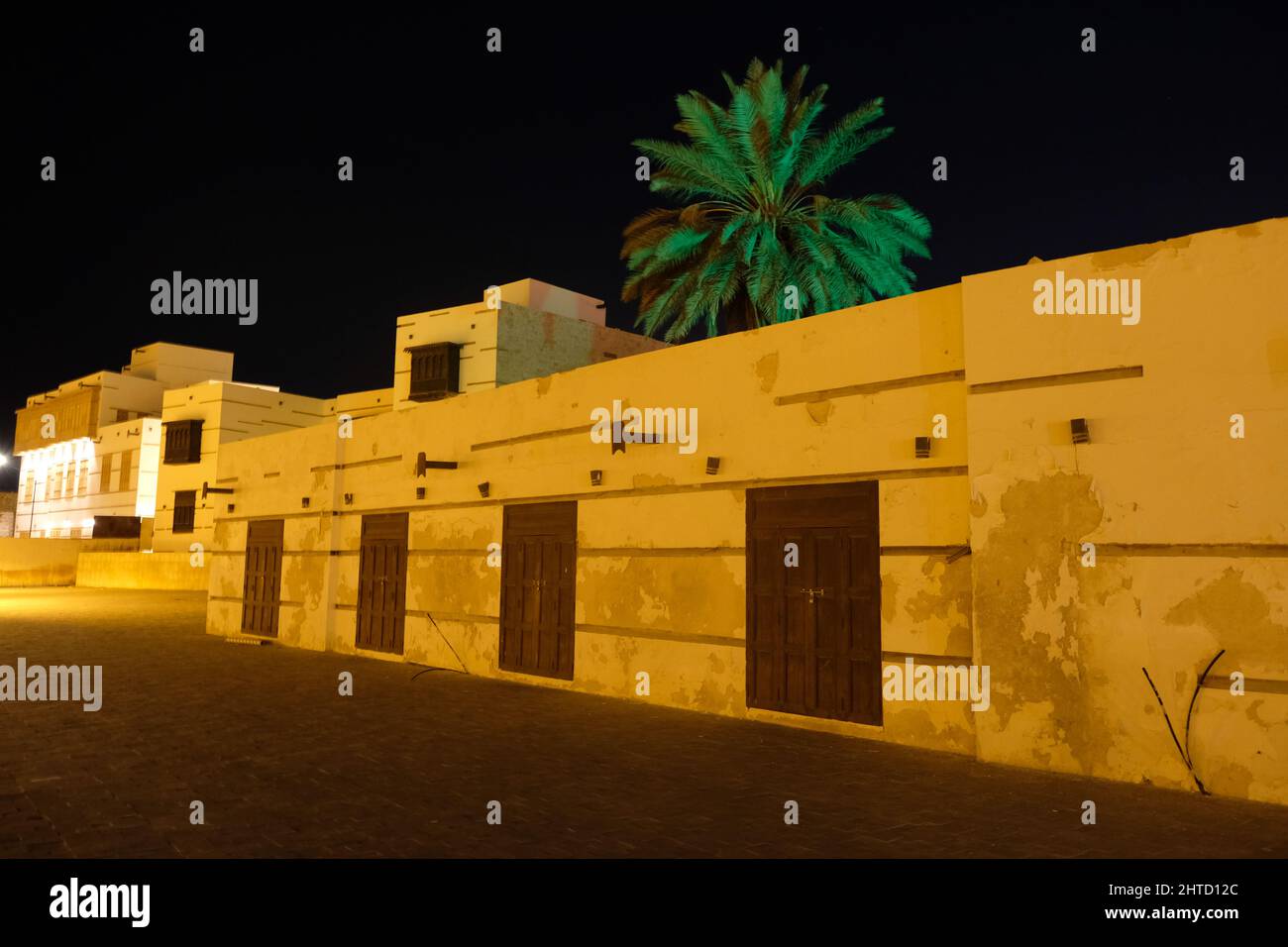 A palm sitting behind stores at the night market (in Arabic suq ellil) in Yanbu Saudi Arabia Stock Photo