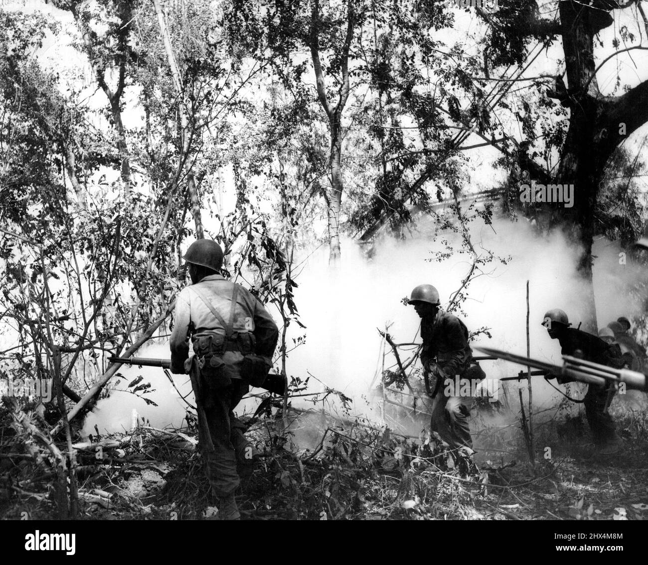 Yanks Advance In Smoke Screen Soldiers of the 1st Infantry regiment, 6th Division, advance in the Cabaruan Hills, Luzon Island, after throwing several smoke grenades ahead. February 19, 1945. (Photo by USA Signal Corps). Stock Photo