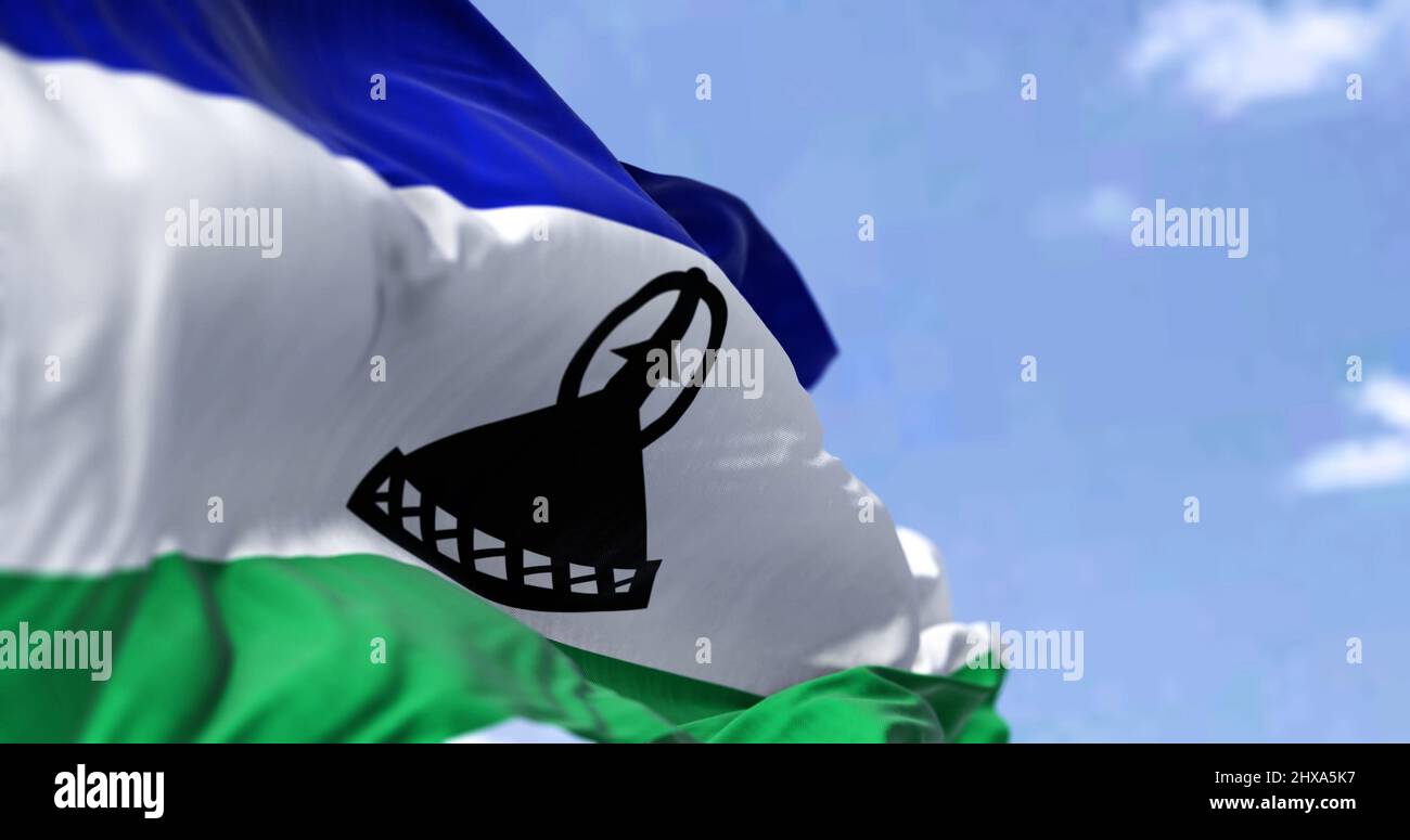 Detail of the national flag of Lesotho waving in the wind on a clear day. Lesotho is an enclaved country surrounded entirely by South Africa. Selectiv Stock Photo