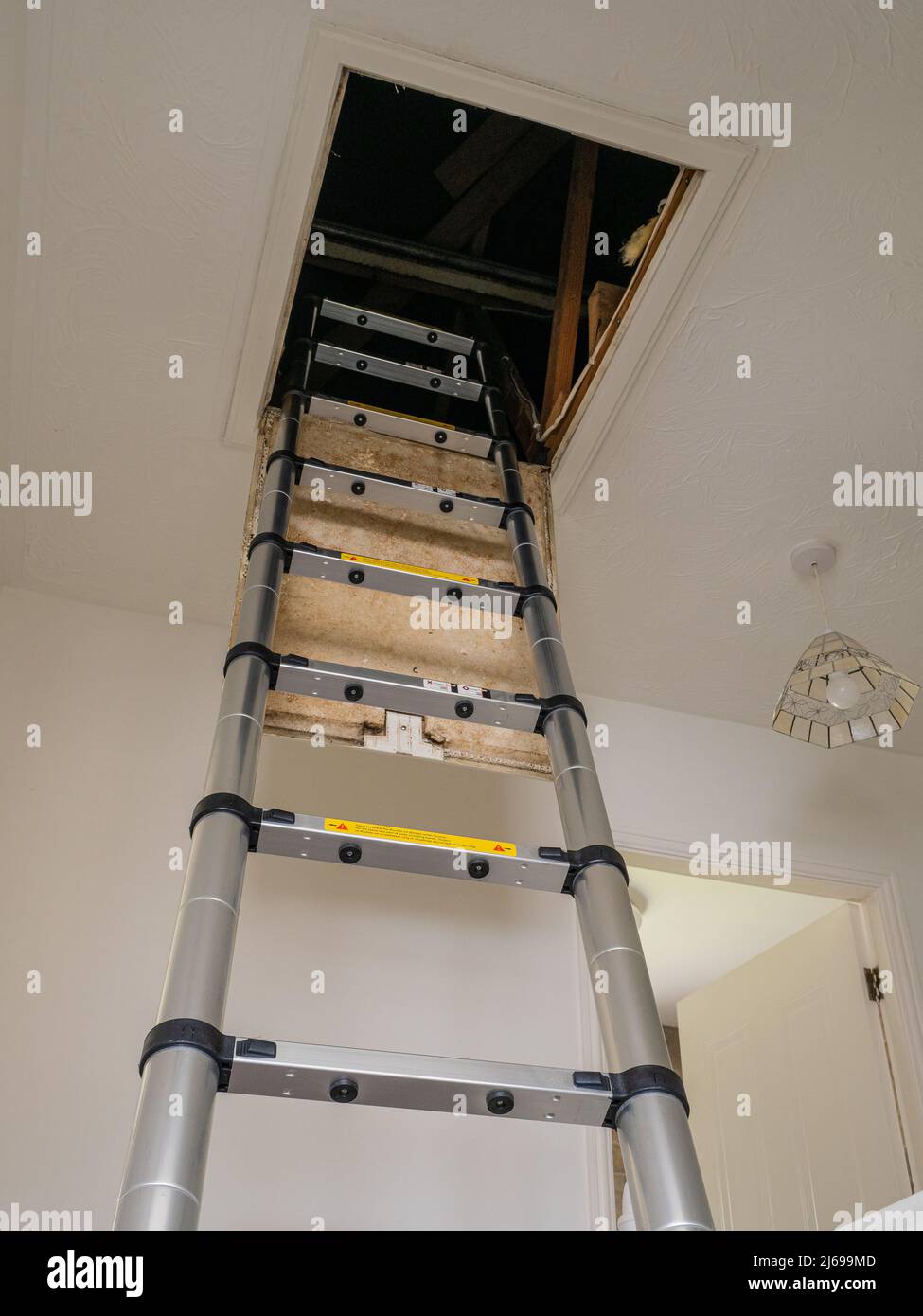 Aluminium Telescopic section loft access ladder through ceiling hatch Stock Photo