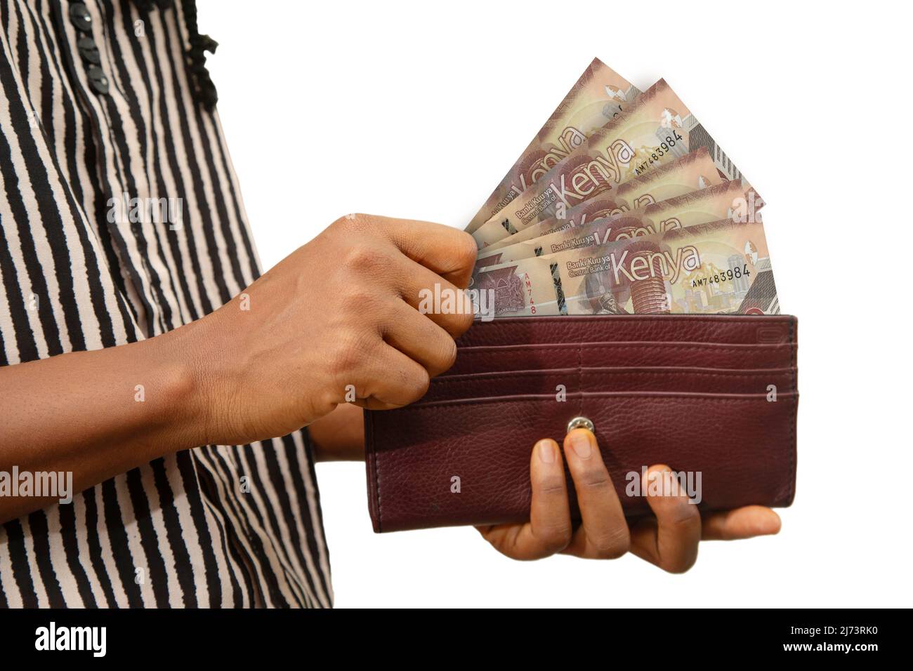 fair Female Hand Holding brown Purse With Kenyan shilling notes, hand removing money out of purse isolated on white. removing money from wallet Stock Photo