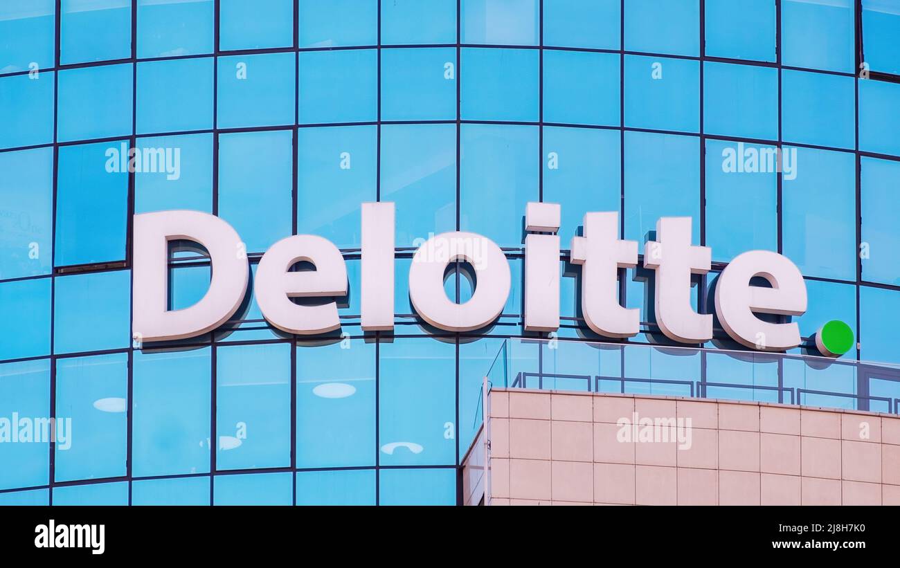 Deloitte sign on the glass facade of an office building Stock Photo