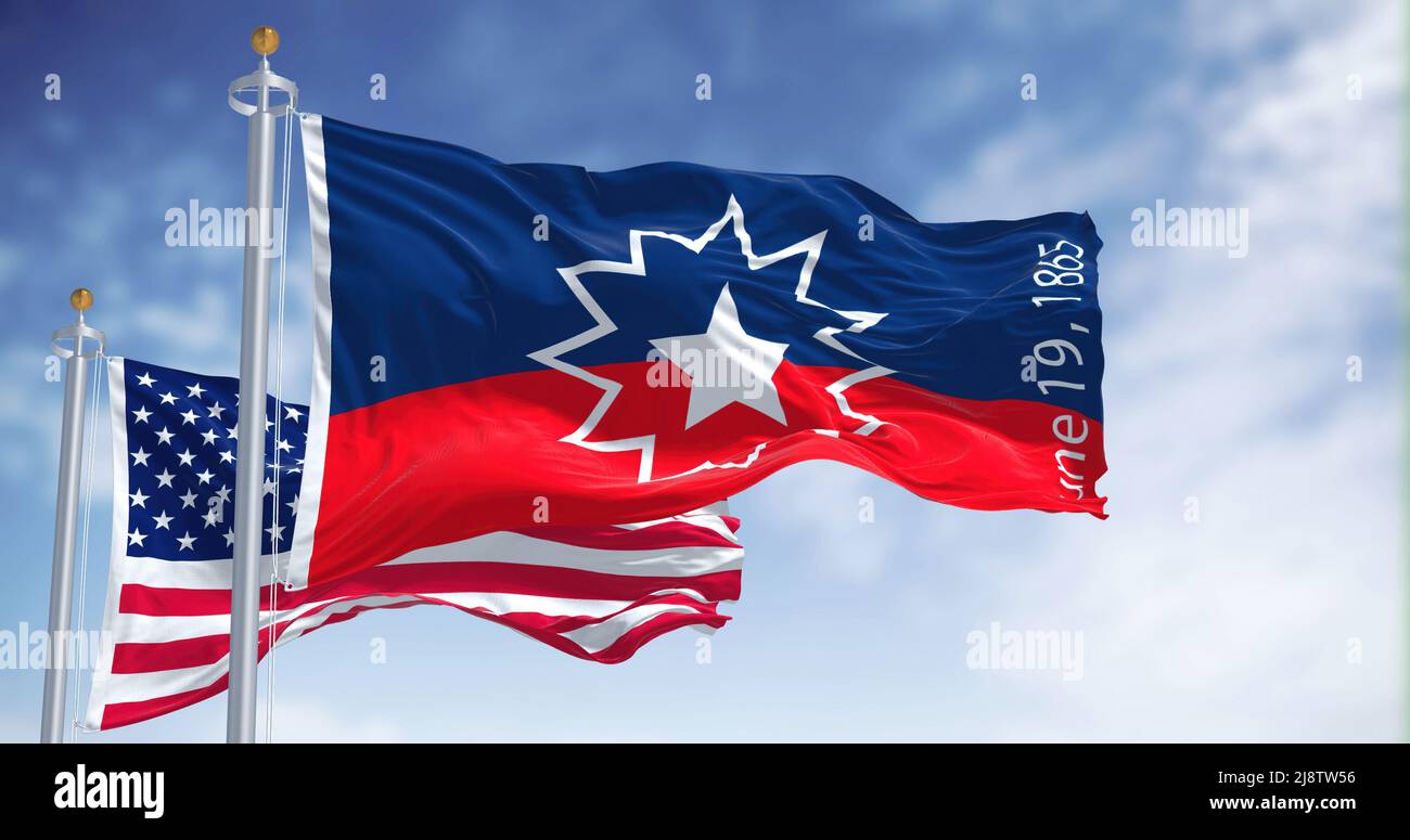 The Juneteenth flag waving in the wind with the american flag. Juneteenth is a federal holiday in the United States commemorating the emancipation of Stock Photo