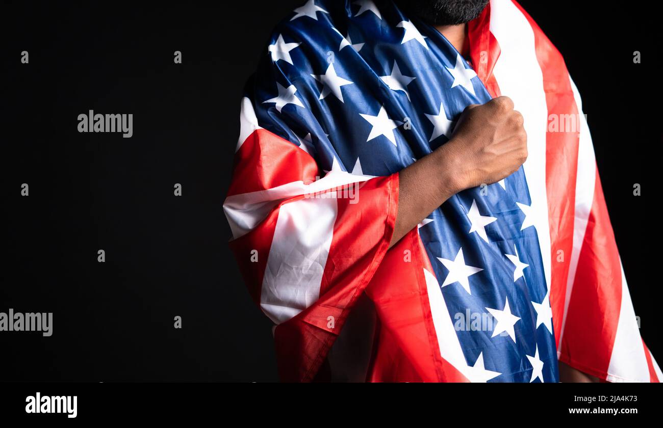 Young man praying by wearing us flag by placing hand on heart - concept of contemplation and freedom. Stock Photo