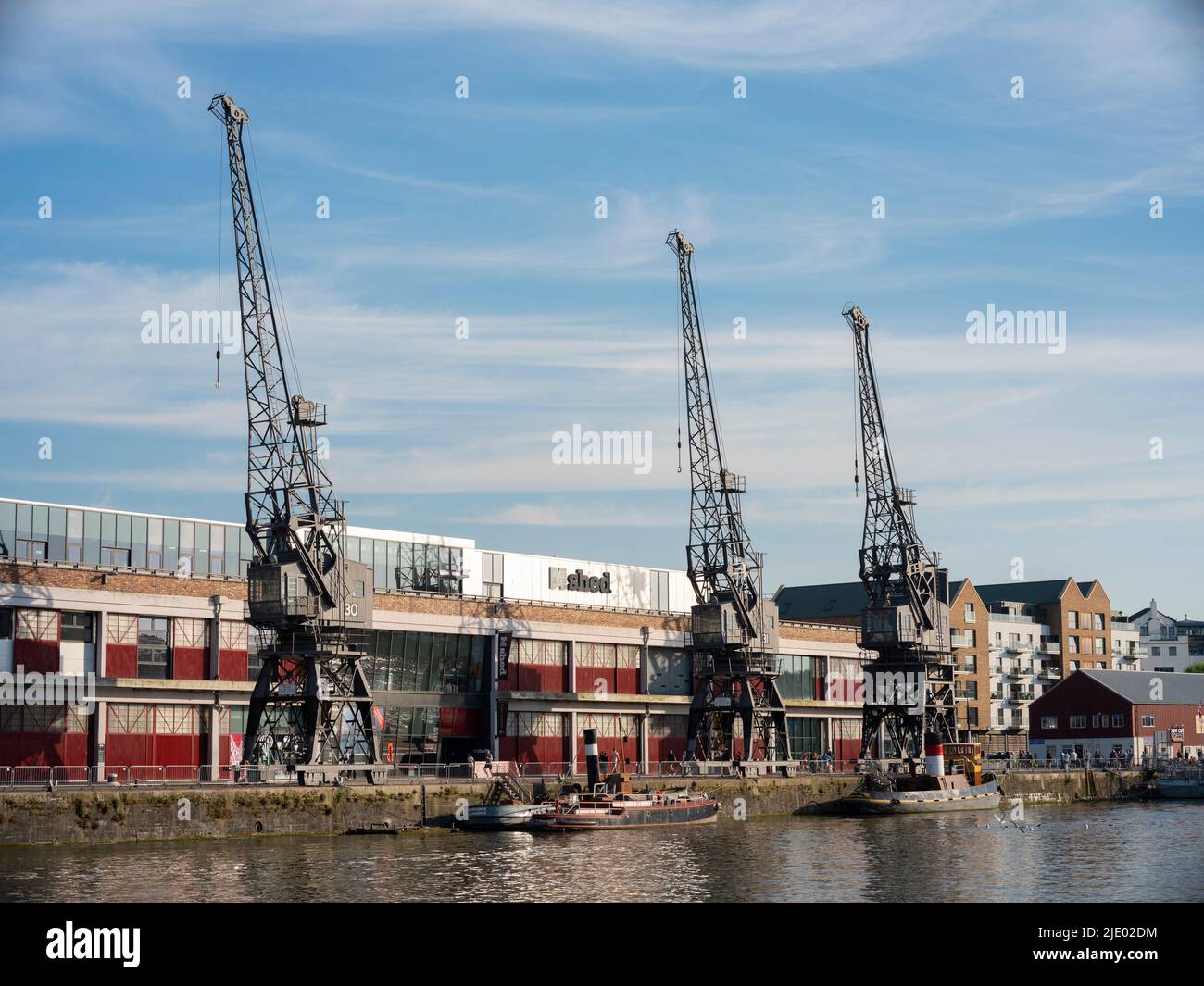 Cranes, rowing boats, and the mShed in the floating harbour harbourside area of Bristol on a sunny summer evening. Stock Photo