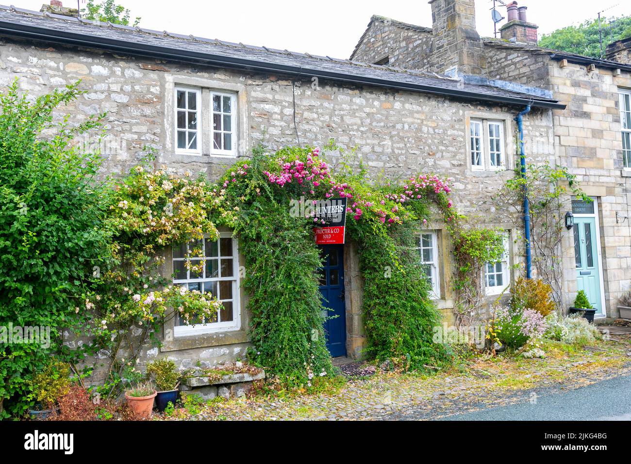 Kettlewell village in the Yorkshire Dales and stone terraced cottages homes with flowers in bloom,Yorkshire,England,UK,summer 2022 Stock Photo