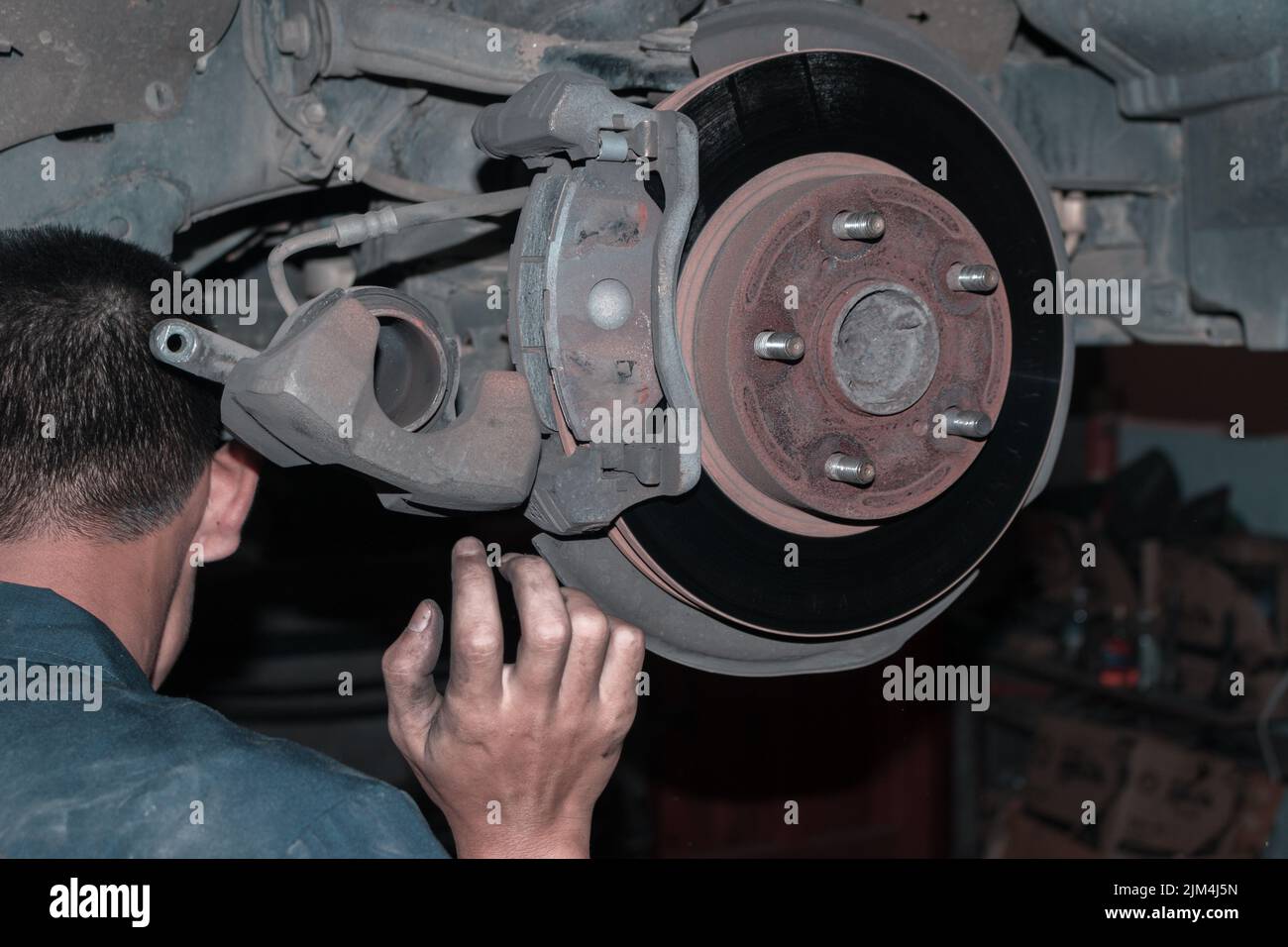 The mechanic is checking the engine. The mechanic is checking the engine. Stock Photo