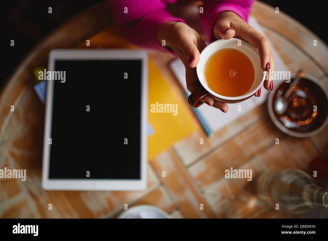 Woman sitting at the table with tea Stock Photo