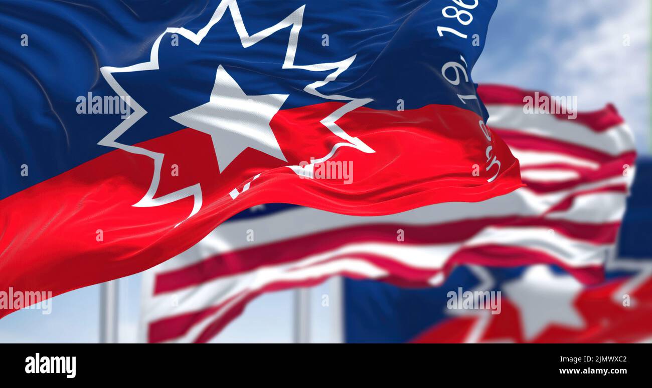 The Juneteenth flag waving in the wind with the american flag Stock Photo