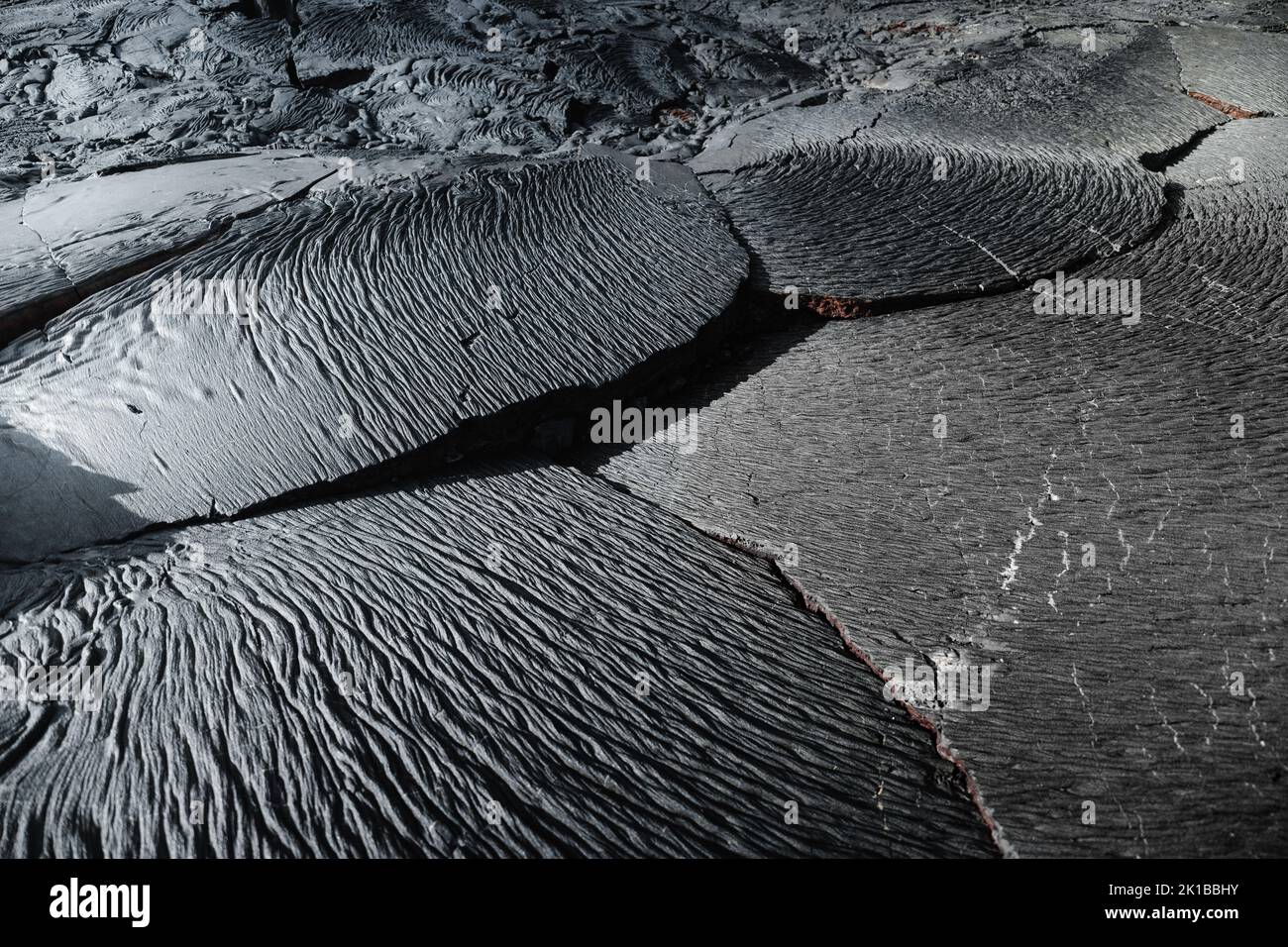 A high-angle view of black cracked rocks Stock Photo