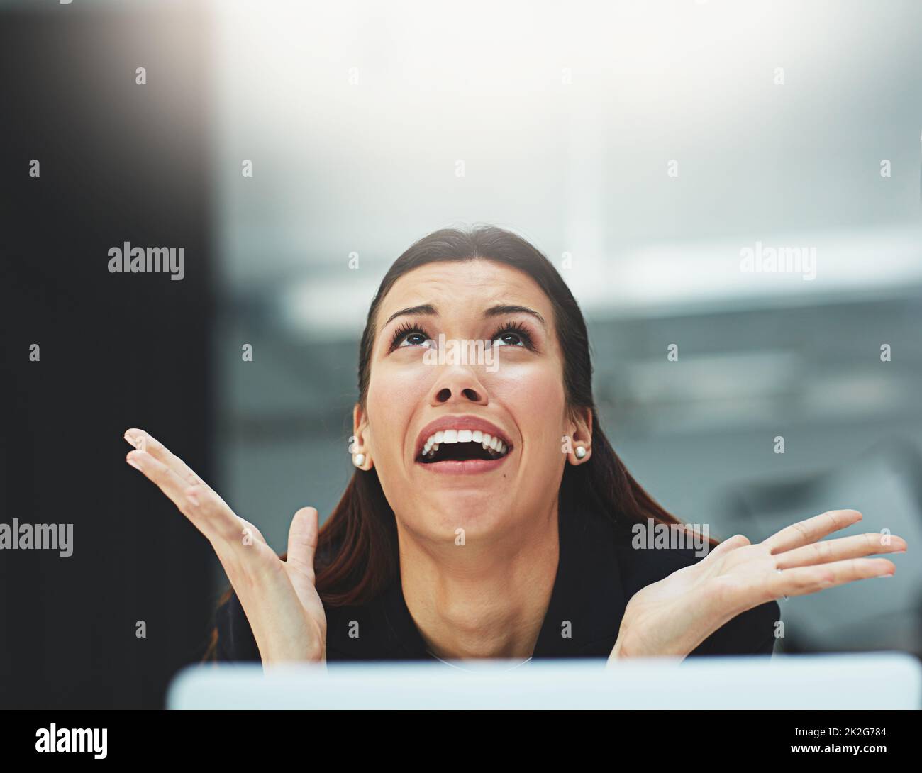 Somebody save me from all this admin. Shot of a frantic businesswoman making a desperate gesture in the office. Stock Photo