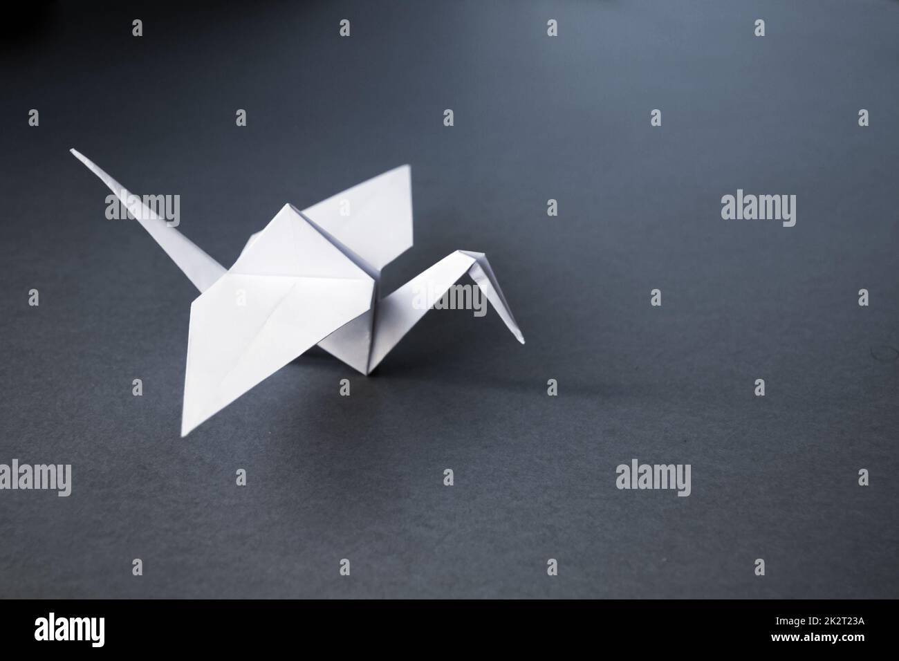 White paper crane origami isolated on a grey background Stock Photo