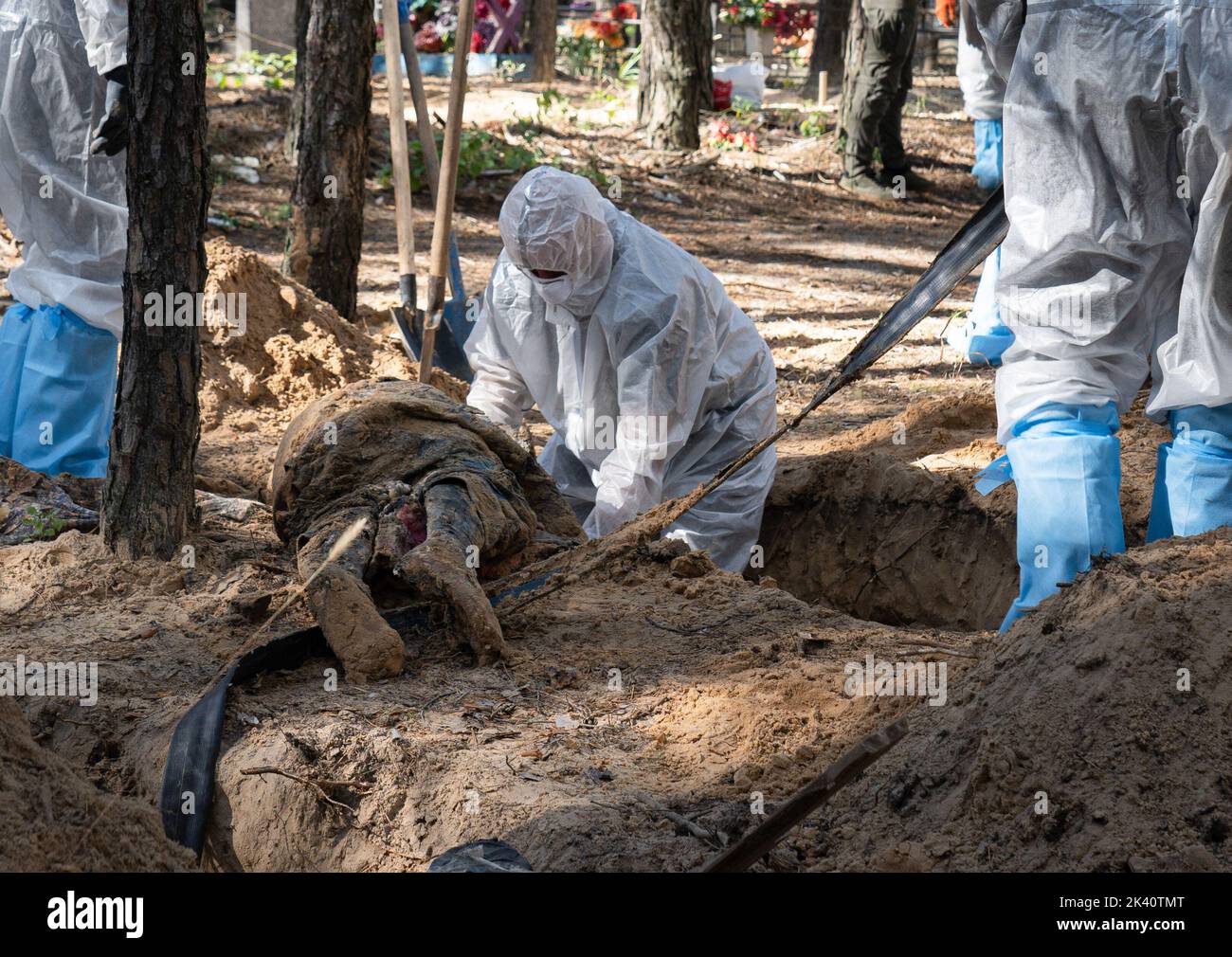 September 19, 2022, Izyum, Ukraine: (EDITORS NOTE: Image depicts death).An investigator wearing protective gear is seen examining an exhumed body. A mass burial site was found in the outskirt of the eastern Ukrainian city, Izyum, Kharkiv region which has been liberated from Russian occupation two weeks ago. At least 445 new graves were found in the site of an existing cemetery while many only have numbers written on the wooden cross. All bodies will be exhumed and sent for forensic examination but it was told from initial investigations that some bodies shown sign of torture. (Credit Image: © Stock Photo