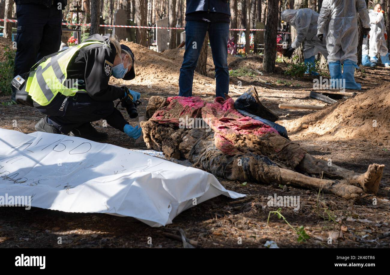 September 19, 2022, Izyum, Ukraine: (EDITORS NOTE: Image depicts death).Investigators are seen examining an exhumed body. A mass burial site was found in the outskirt of the eastern Ukrainian city, Izyum, Kharkiv region which has been liberated from Russian occupation two weeks ago. At least 445 new graves were found in the site of an existing cemetery while many only have numbers written on the wooden cross. All bodies will be exhumed and sent for forensic examination but it was told from initial investigations that some bodies shown sign of torture. (Credit Image: © Ashley Chan/SOPA Images v Stock Photo