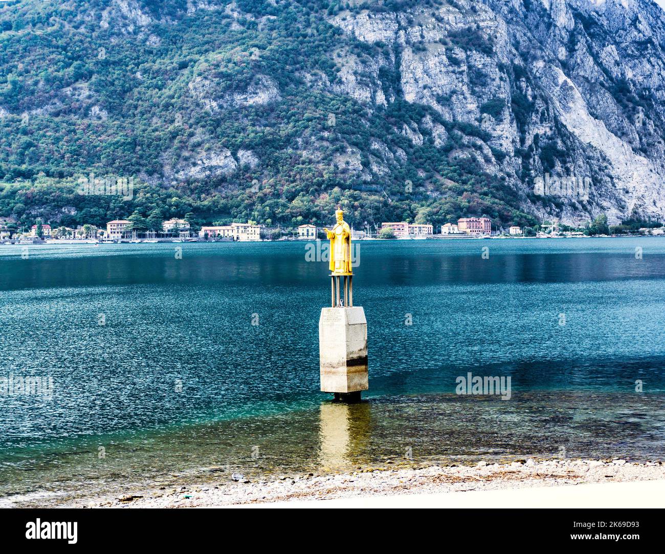 The statue of Saint Nicholas, the patron saint of Lecco, Italy overlooking Lake Como in the harbour of Lecco. Stock Photo