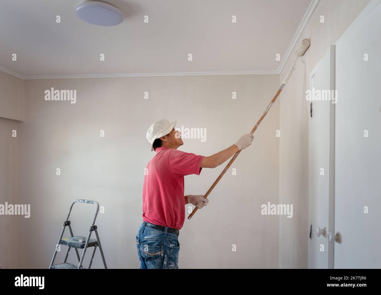 Man painting wall with a roller in home renovation project Stock Photo ...