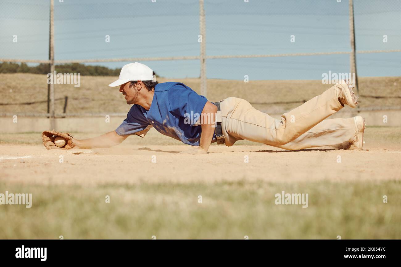 Sports, action and a man catching baseball, sliding in dust on floor with ball in baseball glove. Slide, dive and catch, baseball player on the ground Stock Photo