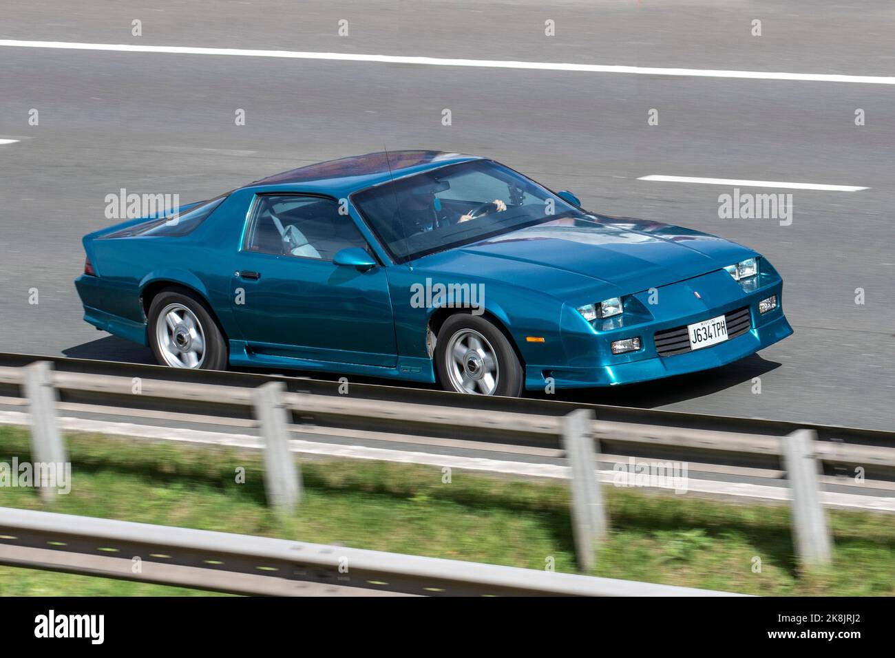 1991 90s, nineties Green Chevrolet GMC left-hand drive CAMARO 5000cc American sports pony car; travelling on the M6 motorway, Manchester, UK Stock Photo