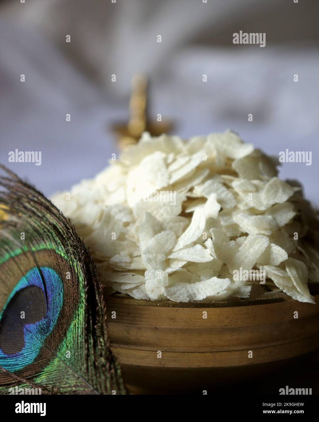 Close-up of raw poha/beaten rice/flattened rice/Brass oil lamp/Peacock feather-Krishna Janmashtami Stock Photo