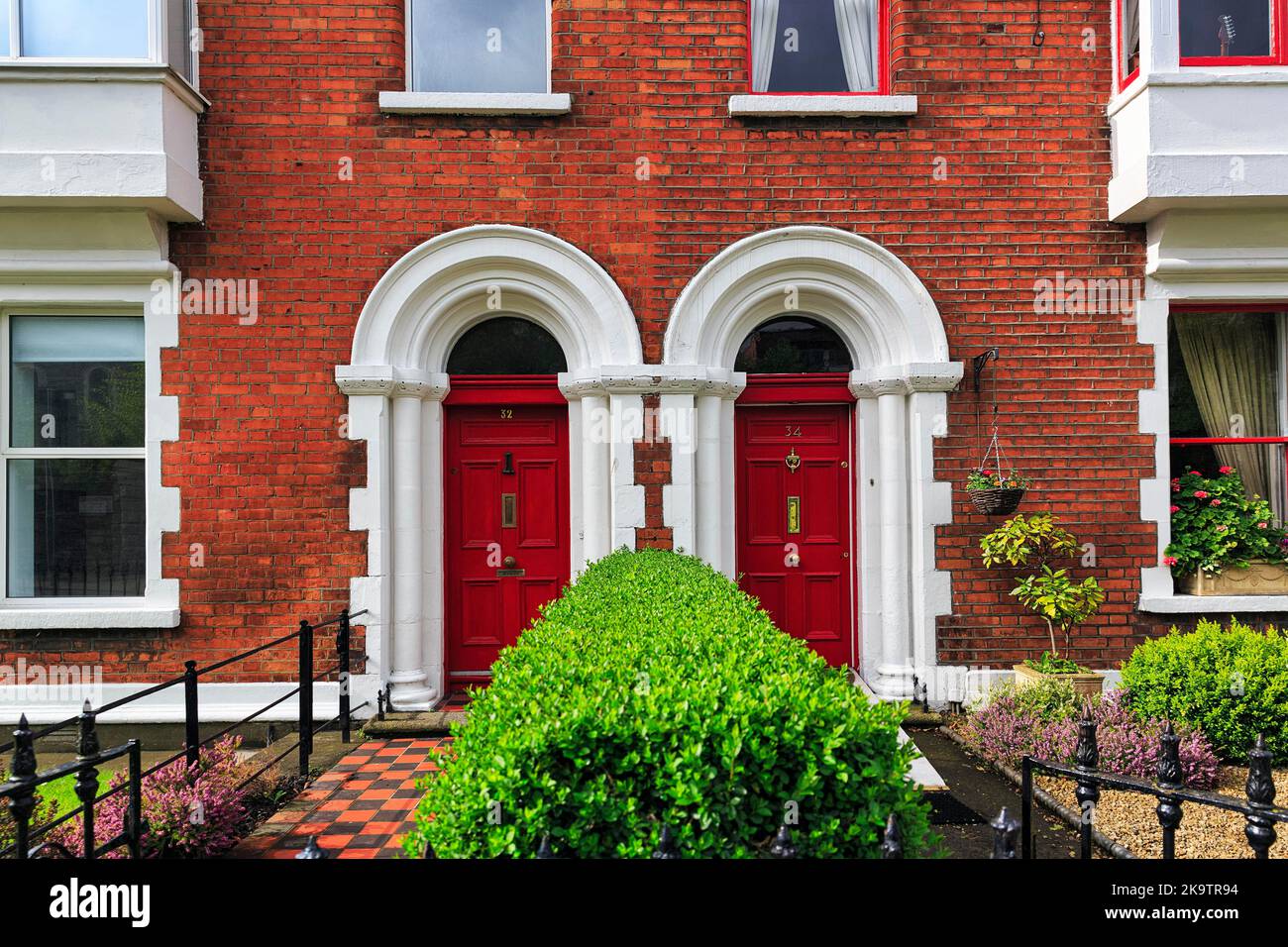 Typical terraced houses with small front garden, two red doors, Dublin, Ireland Stock Photo