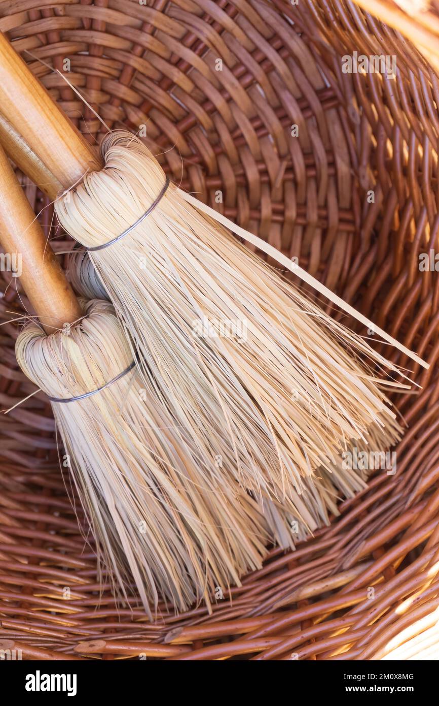 Small eco-friendly handmade brooms in a wicker basket close up Stock Photo