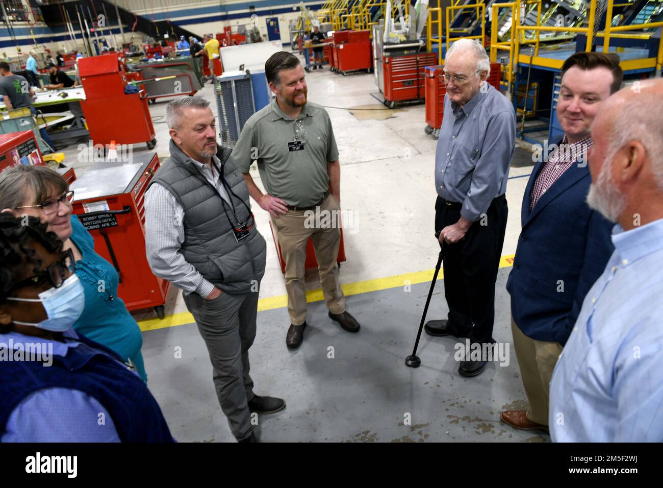 Ryan Arflin, second from right, Warner Robins Air Logistics Complex Training Data Analysis and Training Modernization specialist, his grandfather G. L. Arflin, third from right, and father, Steve Arflin, far right, both Robins Air Force Base retirees, visit with current employees of the Warner Robins Air Logistics Complex 402nd Commodities Maintenance Group at Robins Air Force Base, Georgia, March 10, 2022. The Arflins contributed to almost 80 years of history within the Complex across four generations of their family. Stock Photo