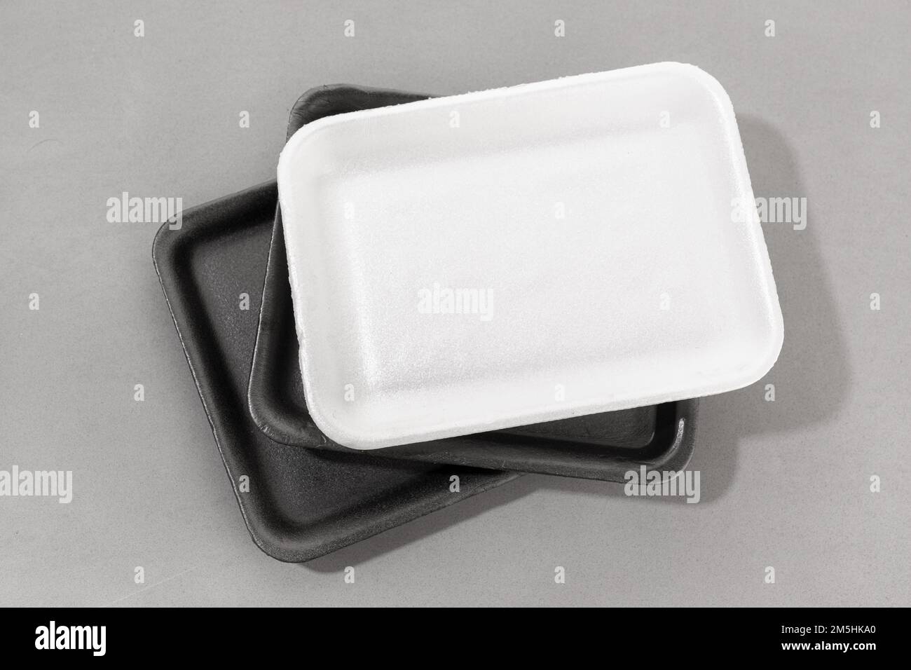 Group of styrofoam trays used for food. Black and white Disposable polystyrene trays isolated on gray background Stock Photo